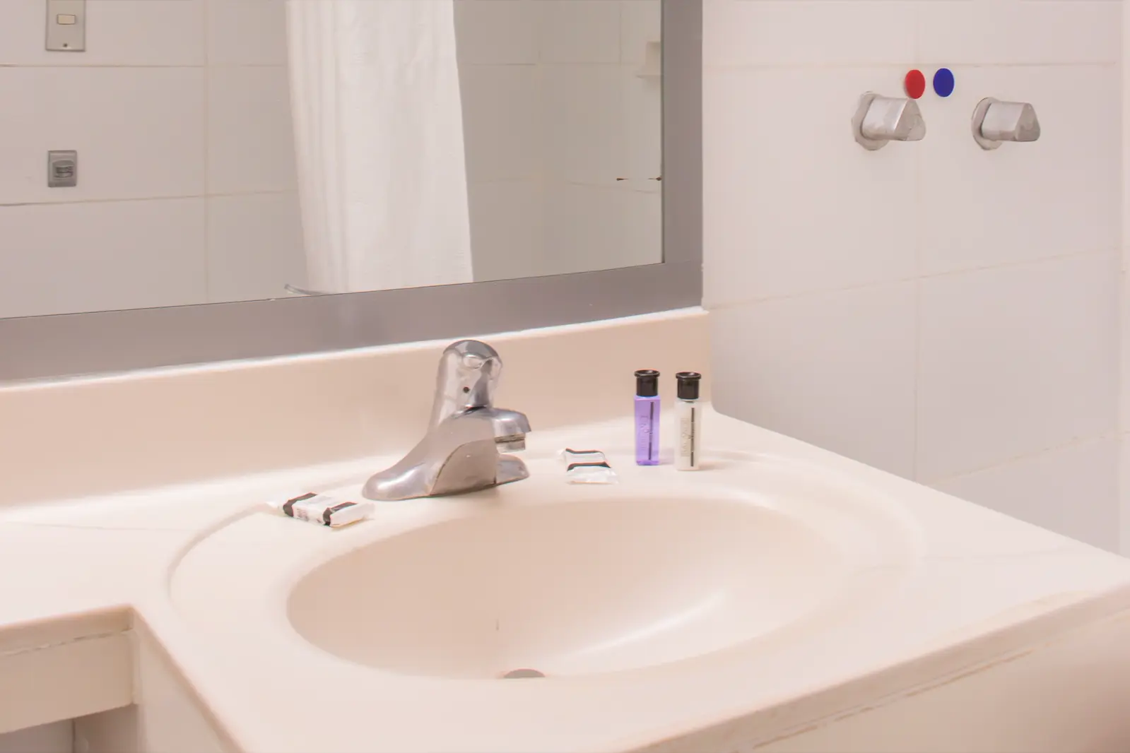 Lavabo y espejo del baño de la habitación