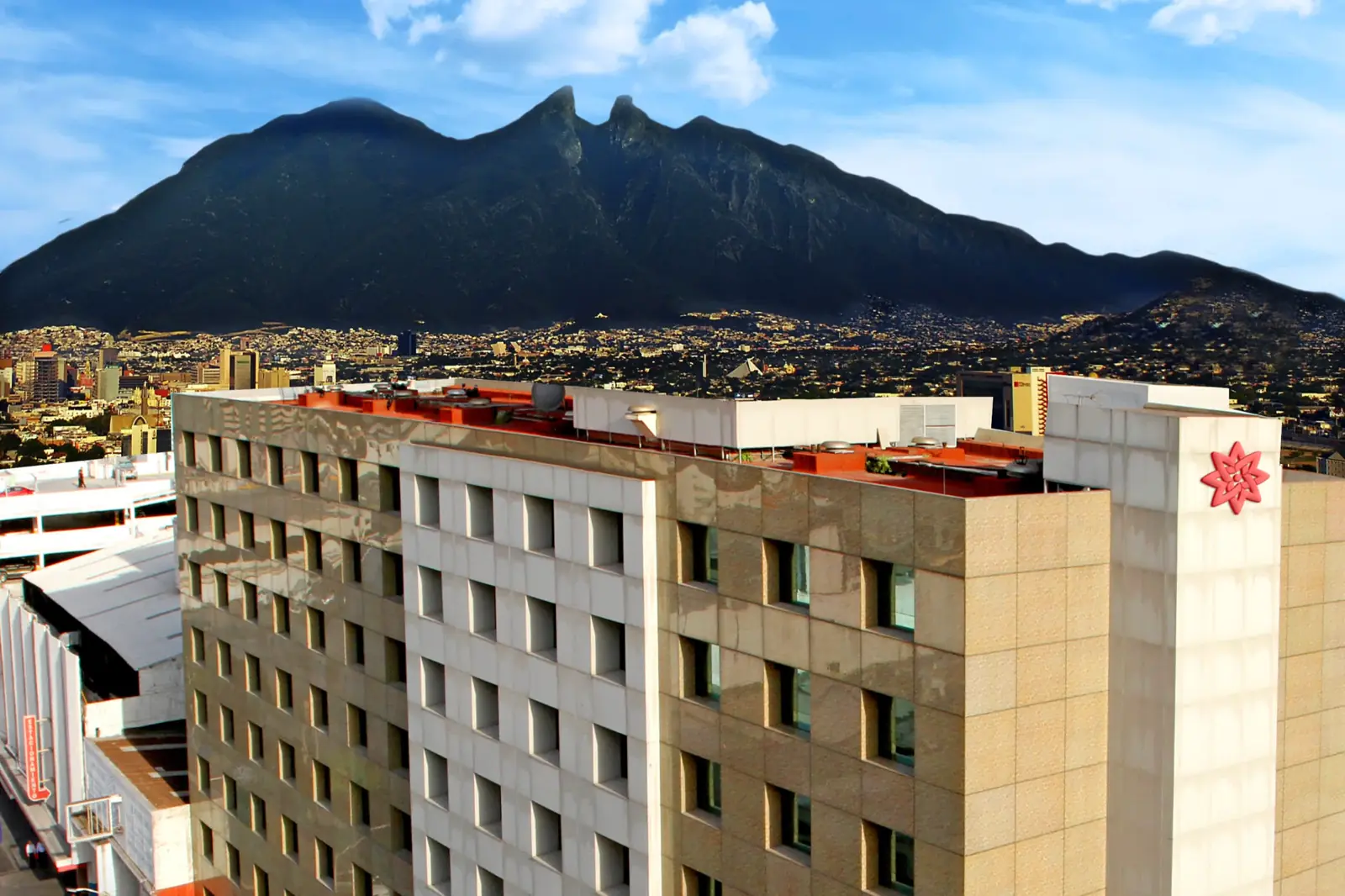 Fachada del Travohotel Monterrey Histórico con el Cerro de la Silla al fondo