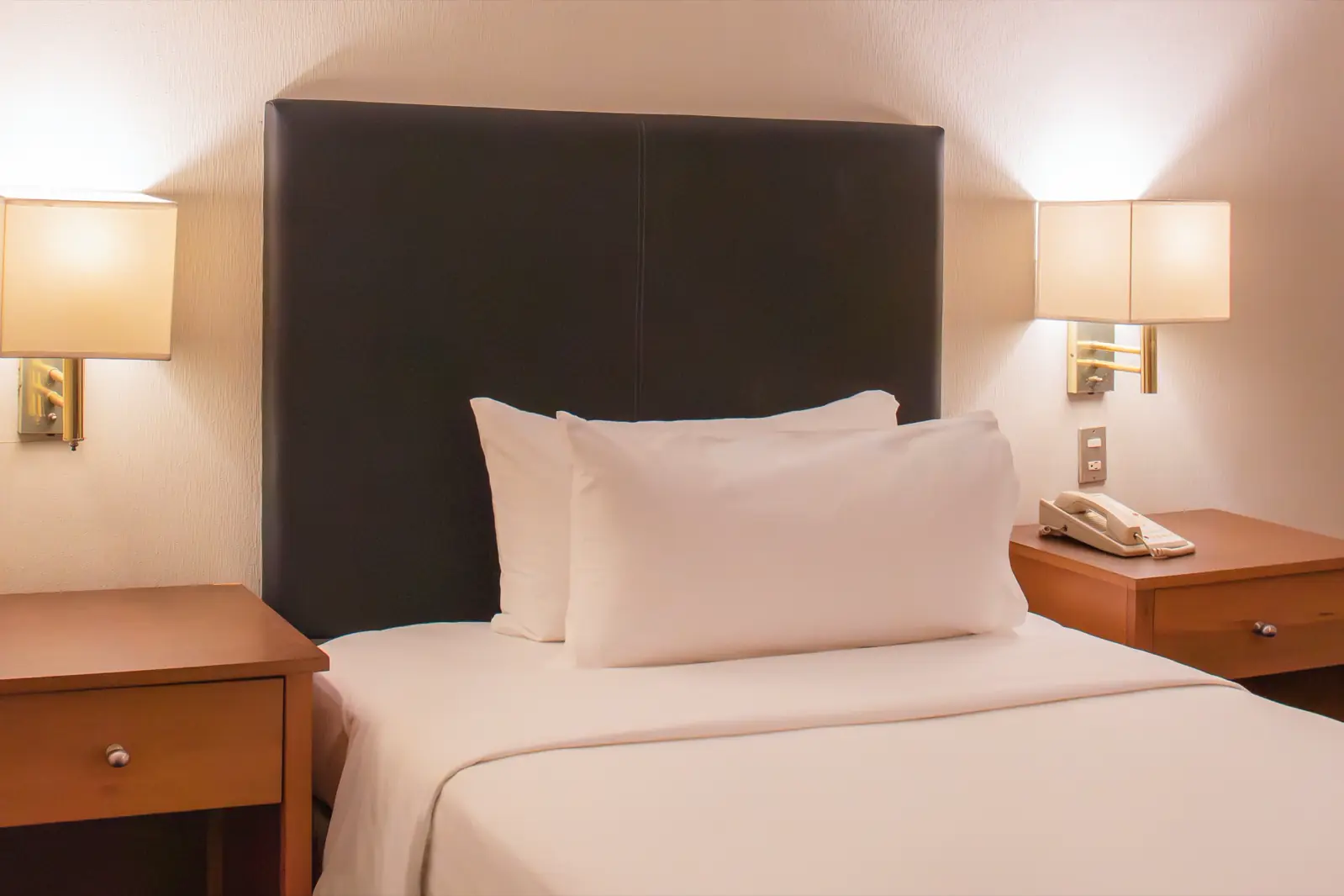 Detalle de la cama king con cabecera de madera